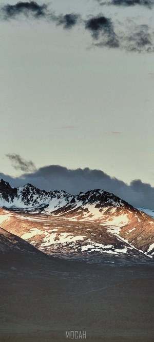 Snow-capped mountains under a cloudy sky