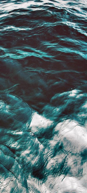 Close-up of dark blue ocean waves with white foam