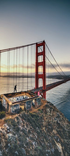 Golden Gate Bridge with a person on a cliff