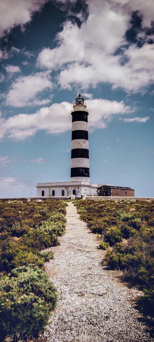 Black and white striped lighthouse on a grassy hill