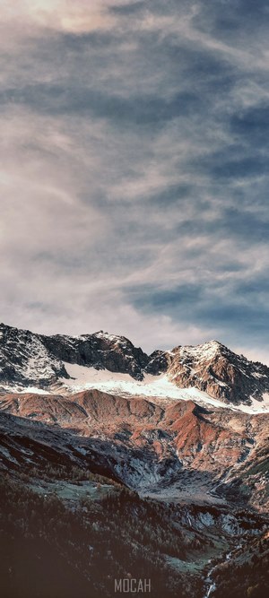 Snow-capped mountains under a cloudy sky