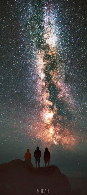 Three people stargazing at the Milky Way