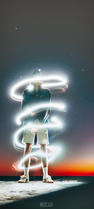 Person surrounded by light trails at night