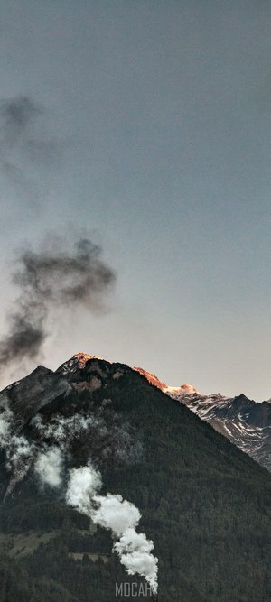 Mountain peak with smoke and snow