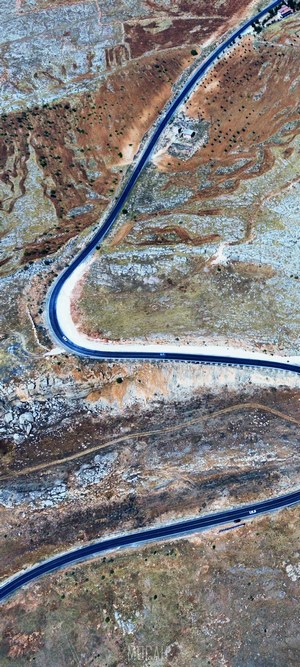 Aerial view of a winding road through a rocky, arid landscape
