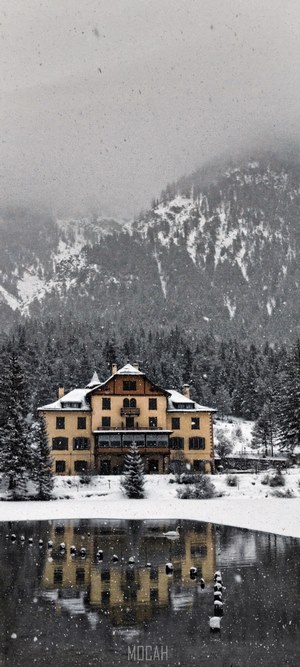 Yellow building reflected in water during snowfall