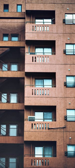 Facade of a brown apartment building with balconies and windows