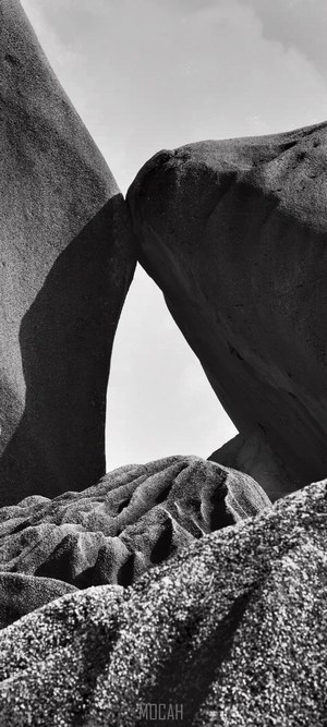 Monochrome image of rock formations against a bright sky