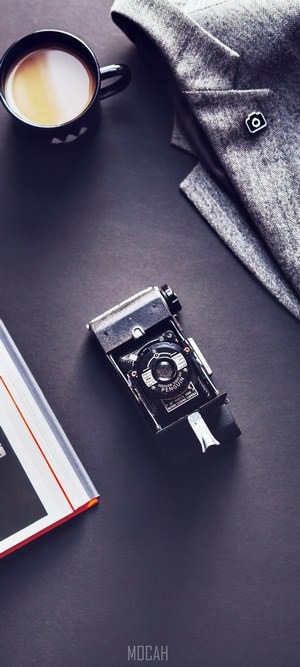 Flatlay of vintage camera, jacket, coffee, and book