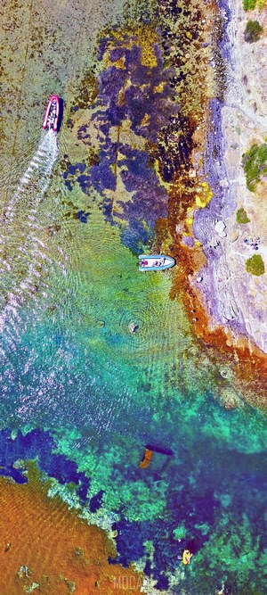 Drone view of boats in colorful shallow waters in Catalunya, Spain