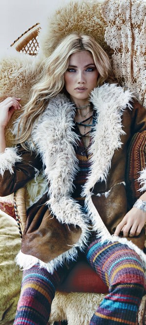 Woman in bohemian fashion with fur coat and striped leggings