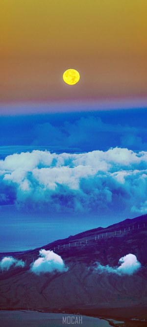 Moonrise over cloudy Haleakala summit with windmills