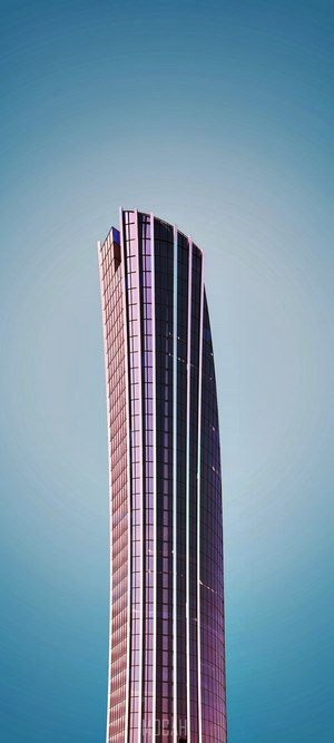 Modern skyscraper with curved glass facade against a clear sky