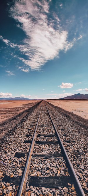 Train tracks in the Bolivian desert under a cloudy sky