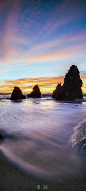 Ocean rocks at sunset with colorful sky