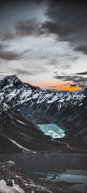 Snow-capped mountains and glacial lake at sunset