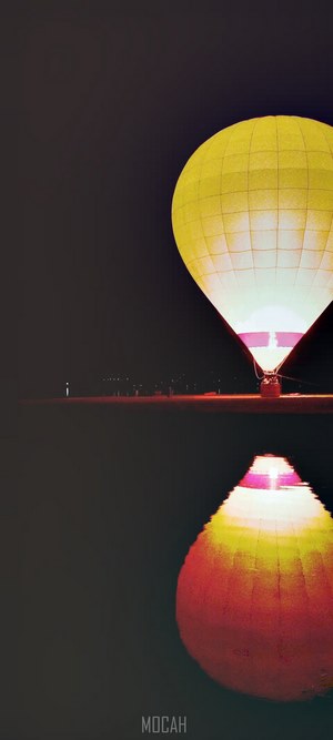 Hot air balloon reflected in water at night