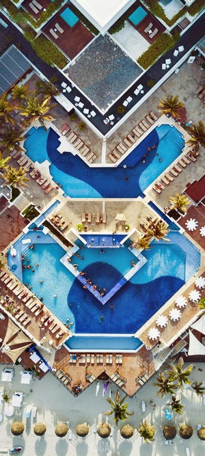 Aerial view of a resort with pools and beach