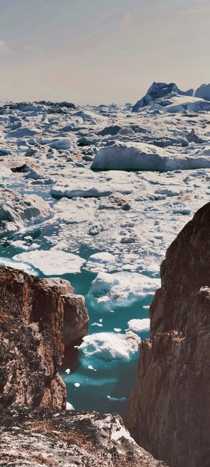 Icebergs floating in a glacial lagoon with rocky cliffs