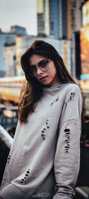 Young woman with glasses and ripped sweatshirt