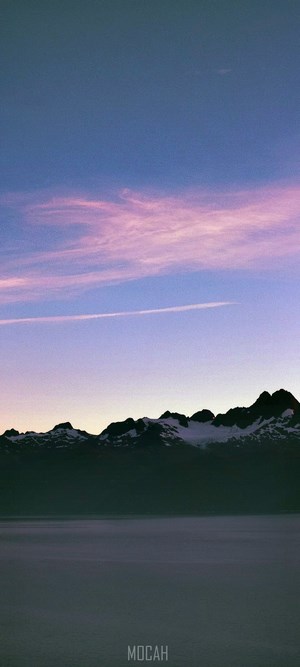 Purple and pink sky over mountains and water