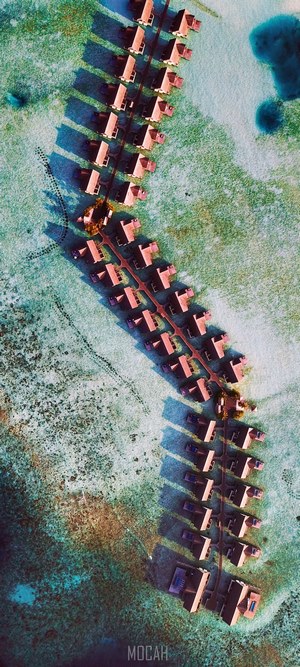 Aerial view of overwater bungalows in turquoise water