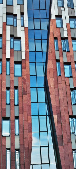 Modern building facade with red stone and blue glass windows