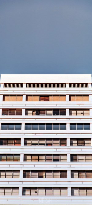 White building with many windows against a blue sky