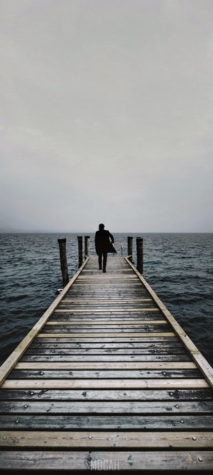 Person walking on a pier on a misty morning