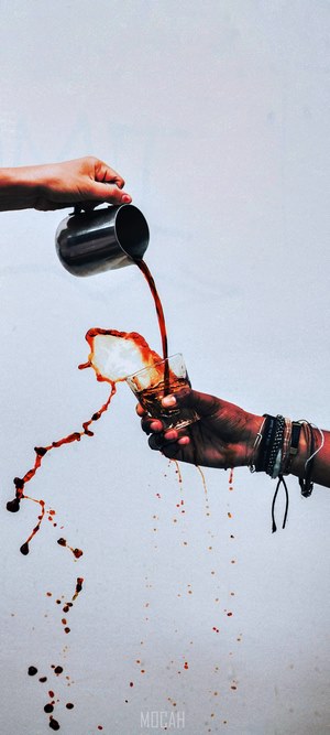 Coffee spilling from pitcher into glass