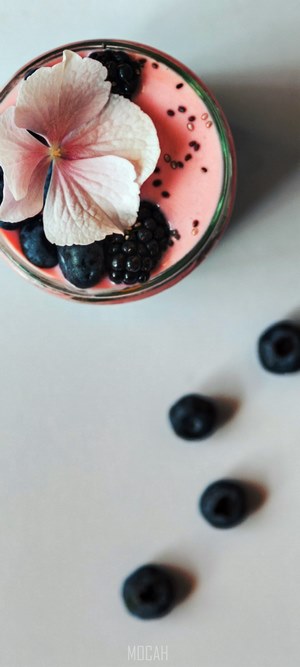 Pink chia pudding with berries and flower