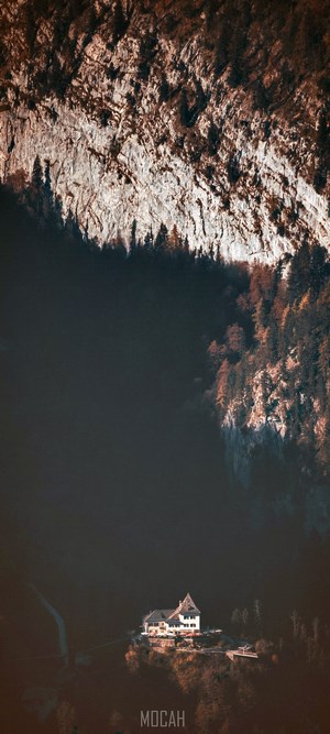 House on a cliffside with a mountain backdrop
