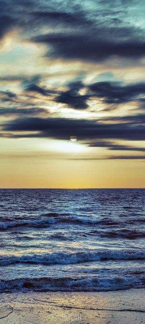 Sunset over the ocean with waves