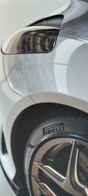 Close-up of a white car's rear tire and taillight with Pirelli branding