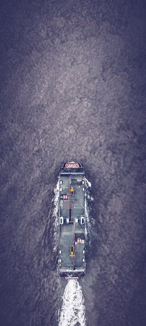 Aerial view of a cargo ship sailing on dark water