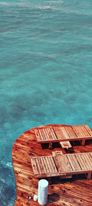 Soneva Jani wooden deck with lounge chairs over turquoise water