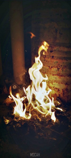 Fire burning in a dark room with a pipe
