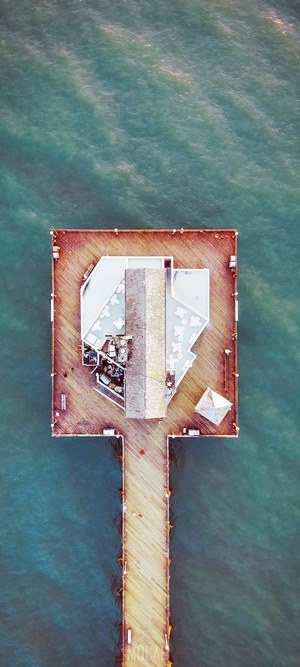 Aerial view of a pier with a building over the ocean