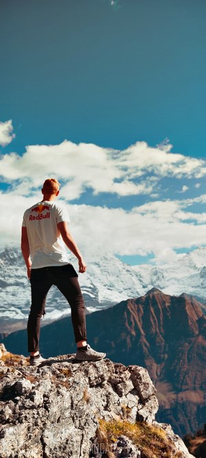 Man in Red Bull shirt on mountain peak