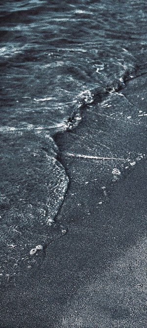 Ocean waves on a dark beach