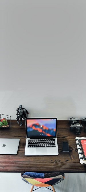 Apple MacBook and cameras on a wooden desk