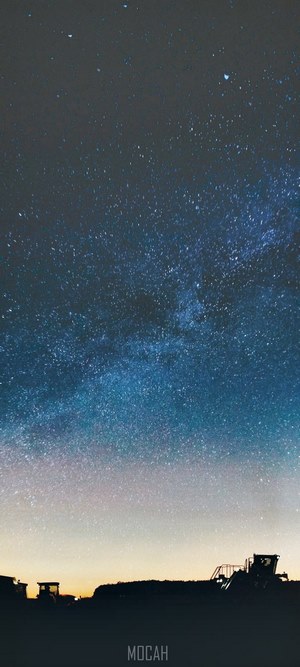 Night sky with Milky Way over silhouetted machinery