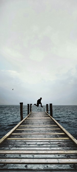Person jumping on a dock over water