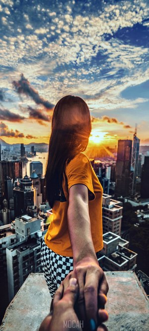 Couple holding hands on a rooftop at sunset