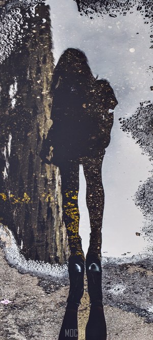 Reflection of a woman in a puddle
