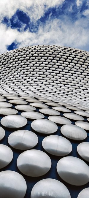Modern building facade with circular patterns and blue sky