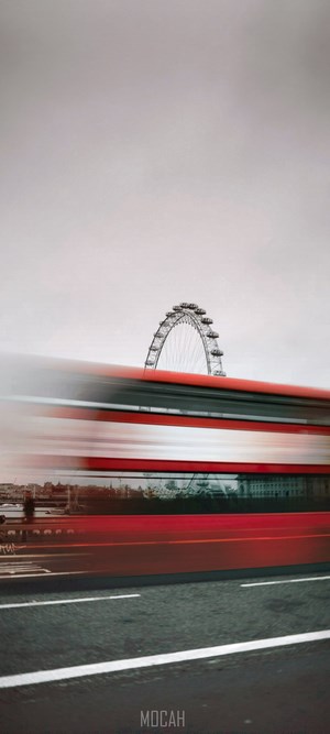 London Eye and blurred red bus on a cloudy day