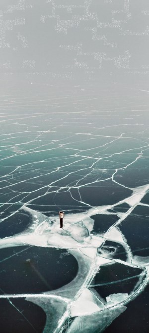 Cracked ice on a lake with a small structure
