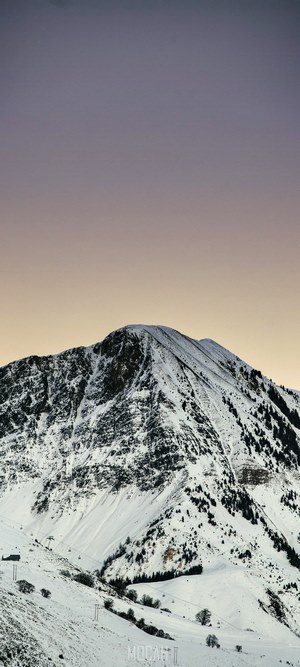 Snow covered mountain against a gradient sky