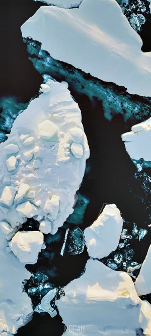 Aerial view of icebergs floating in dark blue water